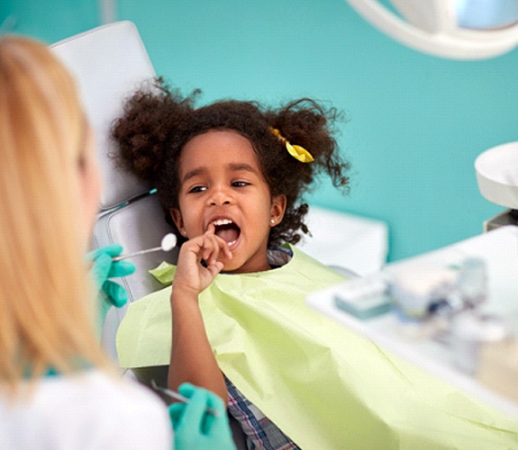 Little girl having her teeth examined by a female dentist