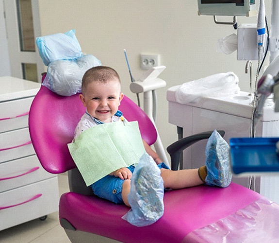 Little boy in patterned shirt having his teeth examined