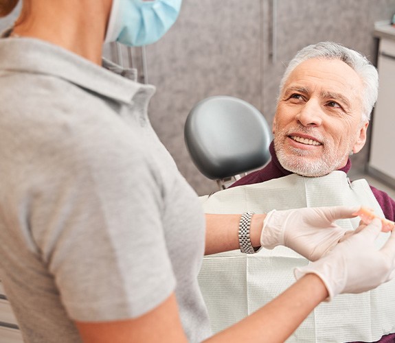 Dentist explaining how to adjust to dentures