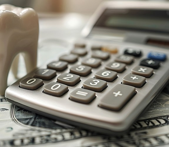 A calculator and money to determine the cost of emergency dentistry in Wilmington 