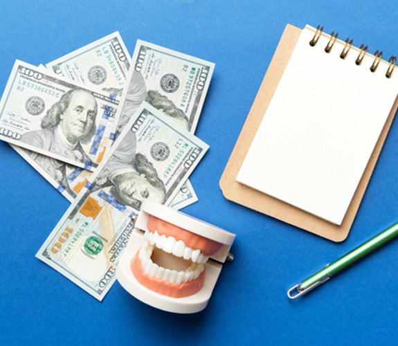 Money and a mouth mold with pen and paper 