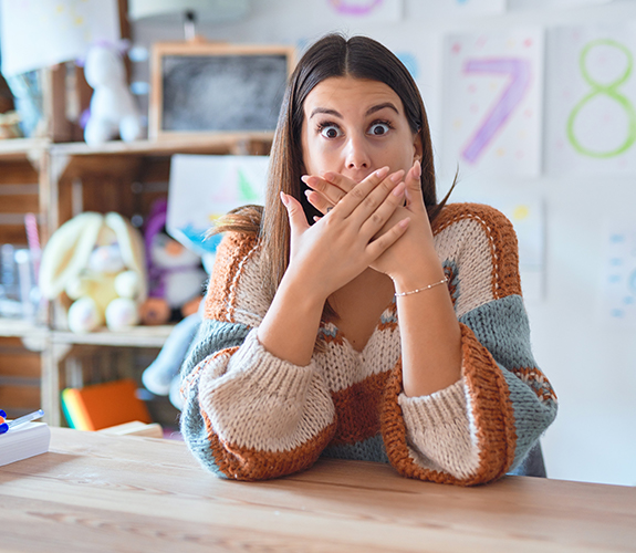 Woman in need of emergency dentistry covering her mouth