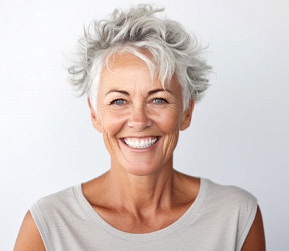 Middle-aged woman with short hair smiling with dental implants