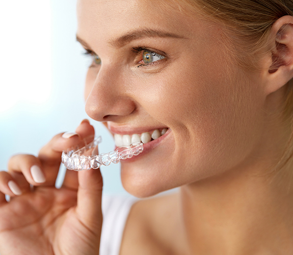 Patient placing her Invisalign tray