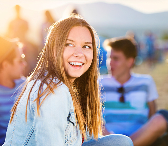 Young woman showing off smile after Invisalign teen treatment