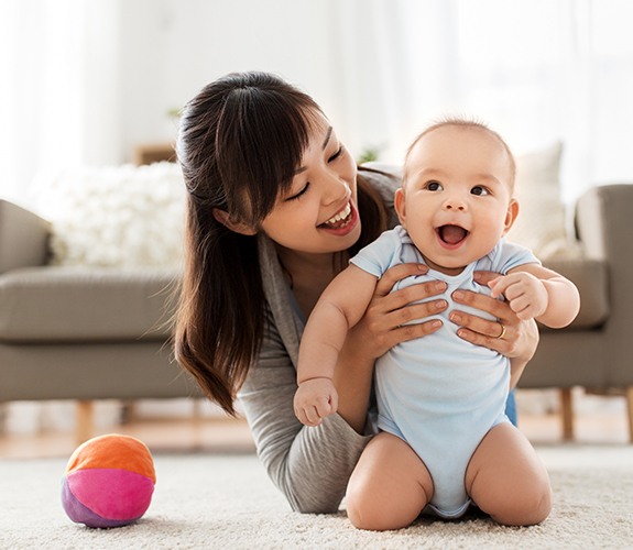 Mother holding sleeping baby after frenectomy for lip and tongue tie