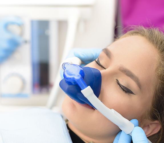 Relaxed patient with nitrous oxide sedation dentistry mask in place