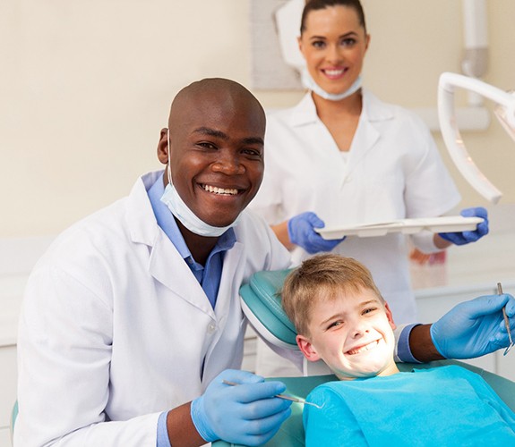 Boy smiling with dentist in Wilmington