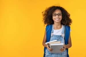 girl wearing a backpack ready for school after dental exam