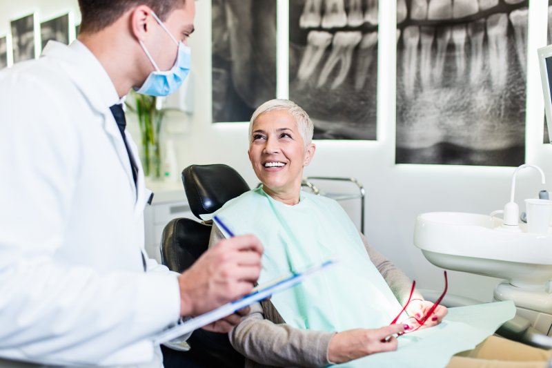 an older woman at the dentist’s office after receiving dental implants  