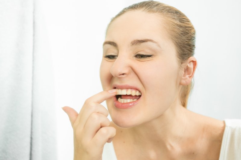 person with something stuck between her teeth  